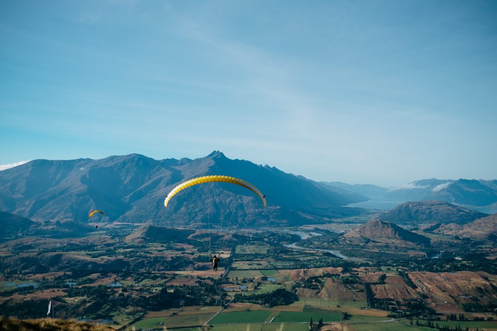 Offer great customer experiences by giving them a chance to share their experience online. Like this person gliding from a parachute over New Zealand