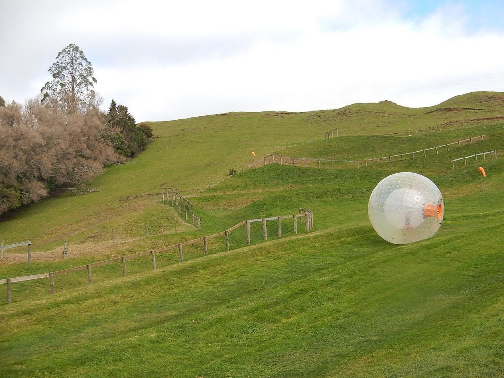ZORB going down a beautiful green hill in New Zealand