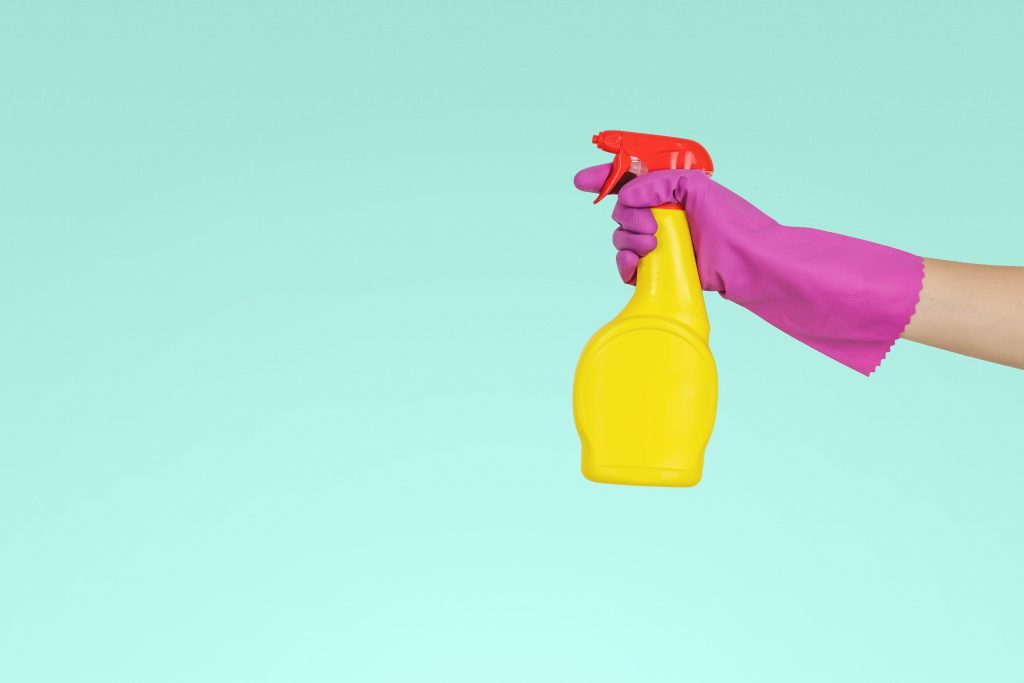 Person using a rubber glove to hold a sanitizing solution