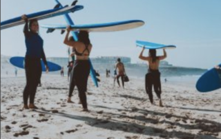 Group with surfboards over their head