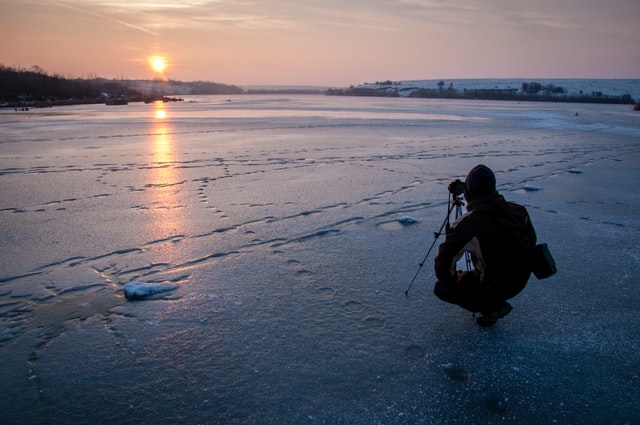 Person taking a picture on a frozen lake